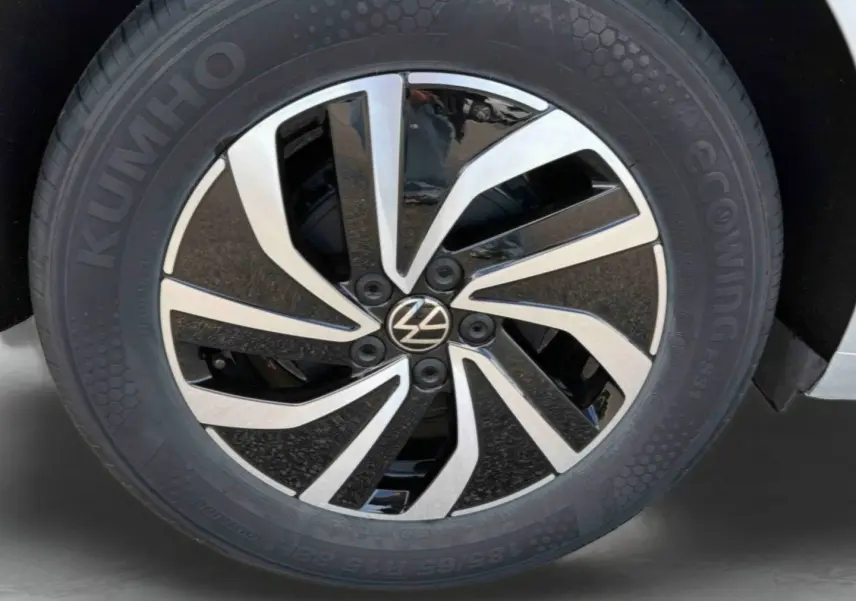 Gros plan sur la jante alliage 15 pouces bicolore noir et argent de la Volkswagen Polo grise 2025.