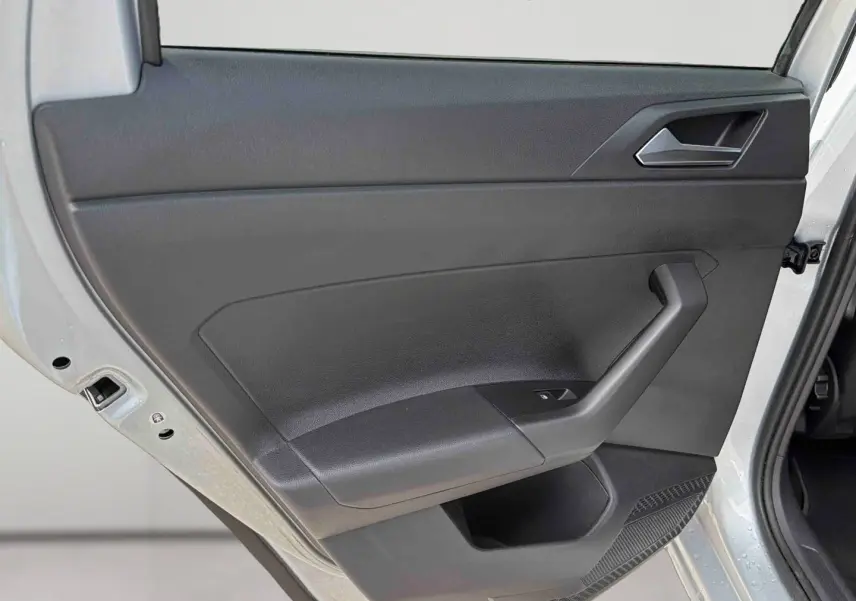 Vue rapprochée de la porte arrière gauche grise d'une Volkswagen Polo 2025 avec poignée et commande de lève-vitre.