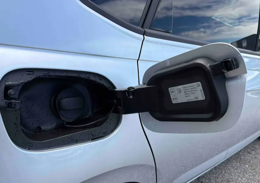 Vue rapprochée de la trappe à carburant ouverte côté gauche d’une Volkswagen Polo grise 2025.