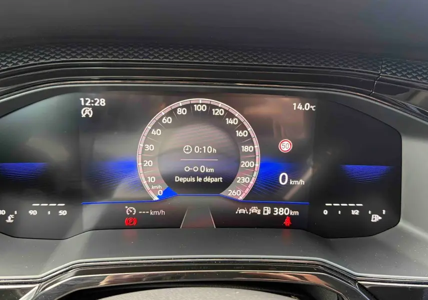 Gros plan sur le combiné d'instruments digital de la Volkswagen Polo grise, affichant la vitesse et la température extérieure.
