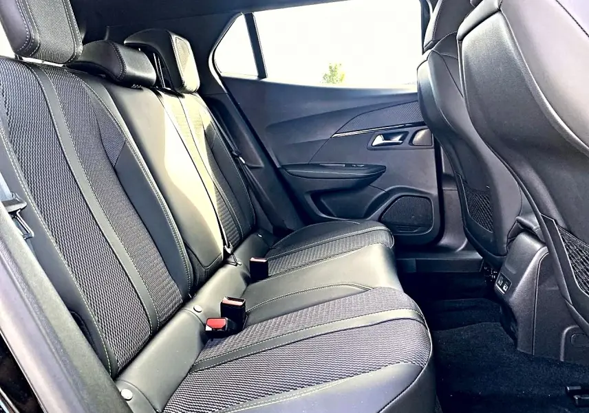 Vue intérieure côté droit des sièges arrière en tissu noir et cuir du Peugeot 2008 1.2 hybrid 145 GT 2025.
