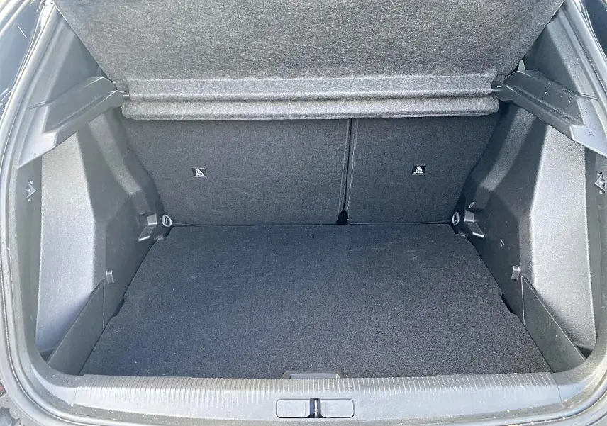 Coffre ouvert de Peugeot 2008 noir, vue arrière montrant l'espace de chargement et la banquette rabattable.