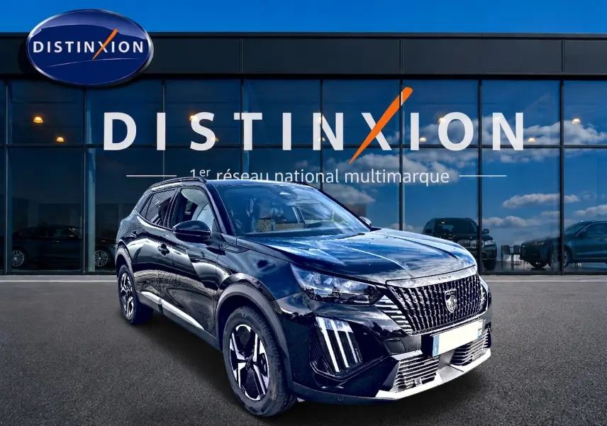 Peugeot 2008 noir en 3/4 avant droit, avec calandre verticale et jantes alu distinctives, devant vitrine Distinxion.