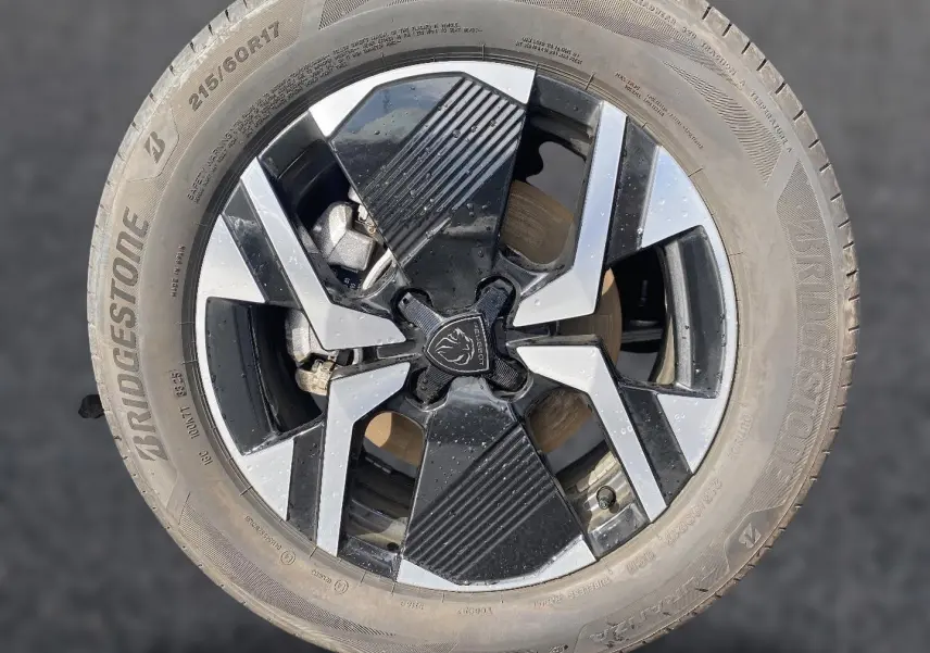 Gros plan sur la jante alu noire et argentée d’un Peugeot 2008 1.2 hybrid 145 GT e-DCS6 avec pneu Bridgestone.