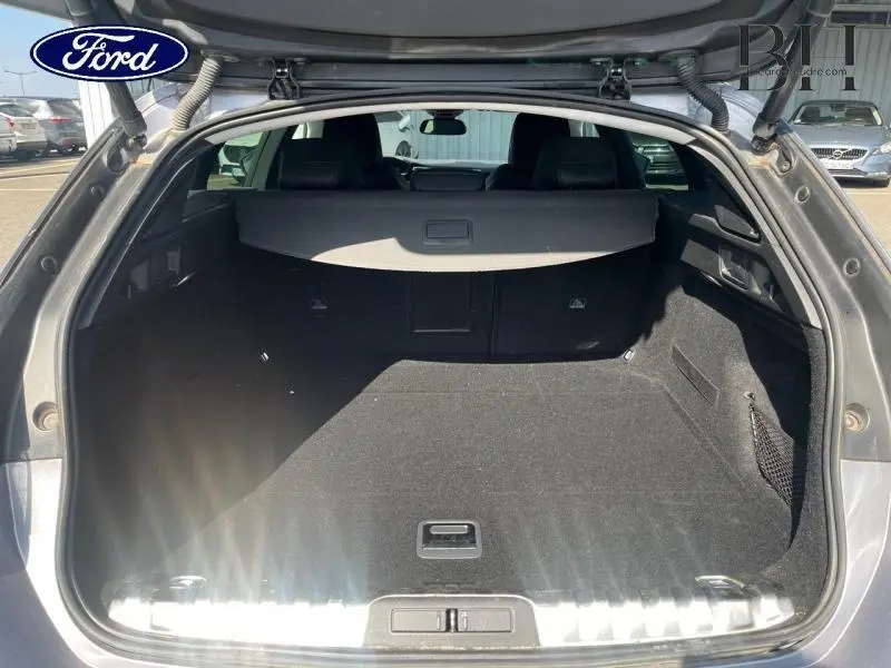 Coffre ouvert vu de l'arrière d'une Peugeot 508 SW gris Artense, montrant l'espace de chargement et la plage arrière.