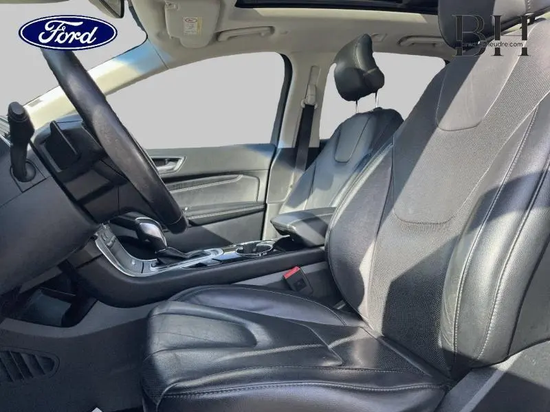 Vue intérieure côté conducteur du Ford Edge 2016 avec sièges en cuir noir et console centrale équipée.