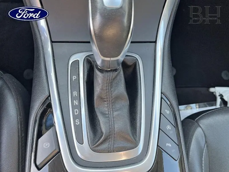 Vue rapprochée du levier de vitesses automatique en cuir noir du Ford Edge blanc Platinum de 2016.