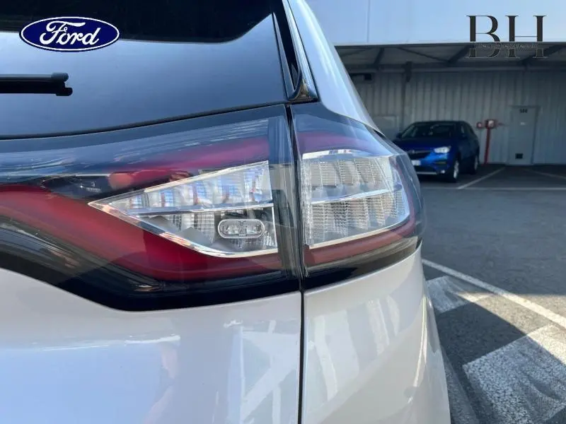 Gros plan sur le feu arrière droit du Ford Edge blanc Platinum, soulignant les détails lumineux modernes.