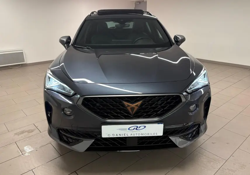 Vue frontale d'un CUPRA Formentor 1.5 TSI 150 DSG7 VZ-LINE gris magnétique avec calandre noire et logo cuivré.