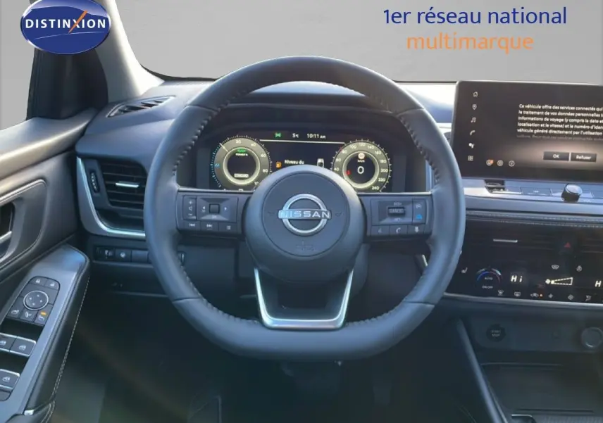 Vue intérieure centrée sur le volant Nissan du Qashqai 2025, tableau de bord digital et écran tactile visibles.