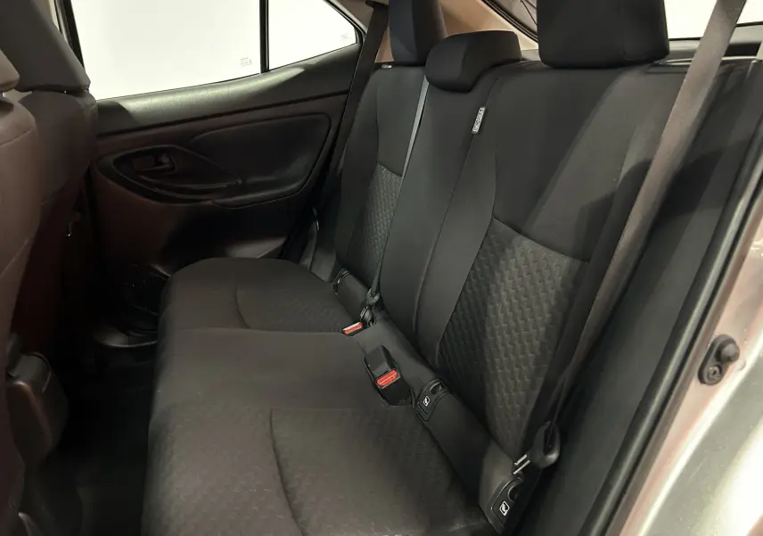 Vue intérieure côté droit des sièges arrière en tissu noir de la Toyota Yaris Cross gris minéral, avec ceinture de sécurité visible.