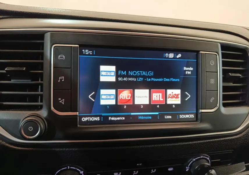 Écran tactile central du Peugeot Expert Fourgon blanc 2023 affichant les stations radio FM, entouré de commandes noires.