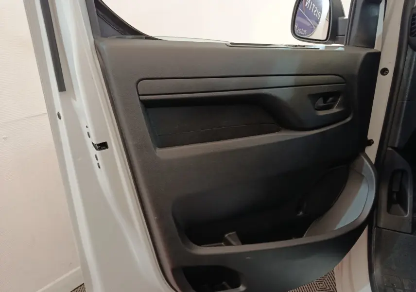 Vue intérieure côté gauche de la porte avant blanche du Peugeot Expert Fourgon avec panneau de porte noir et poignée intégrée.