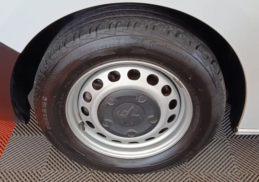 Gros plan sur la roue avant droite du Peugeot Expert Fourgon blanc, mettant en valeur la jante acier et le pneu Continental.