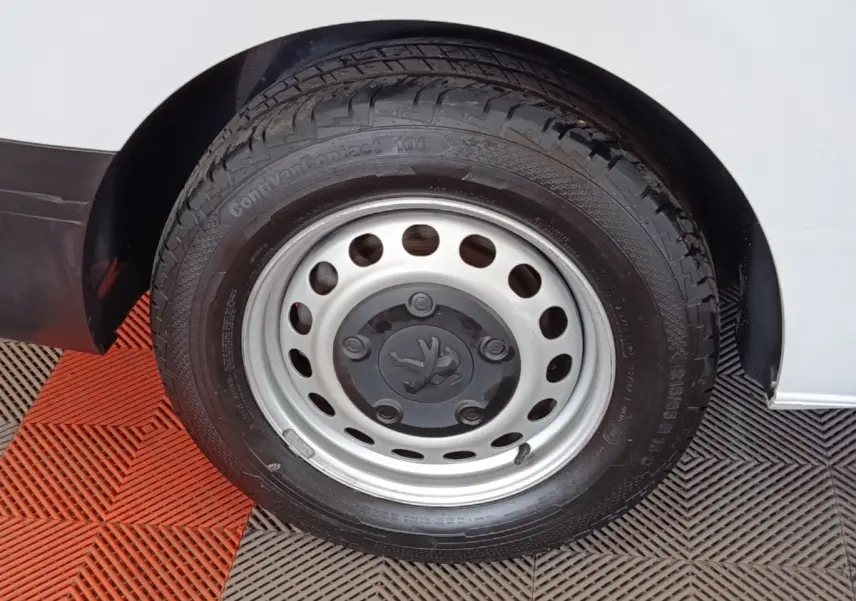 Gros plan sur la roue avant droite du Peugeot Expert Fourgon blanc, avec jante acier et logo Peugeot central.