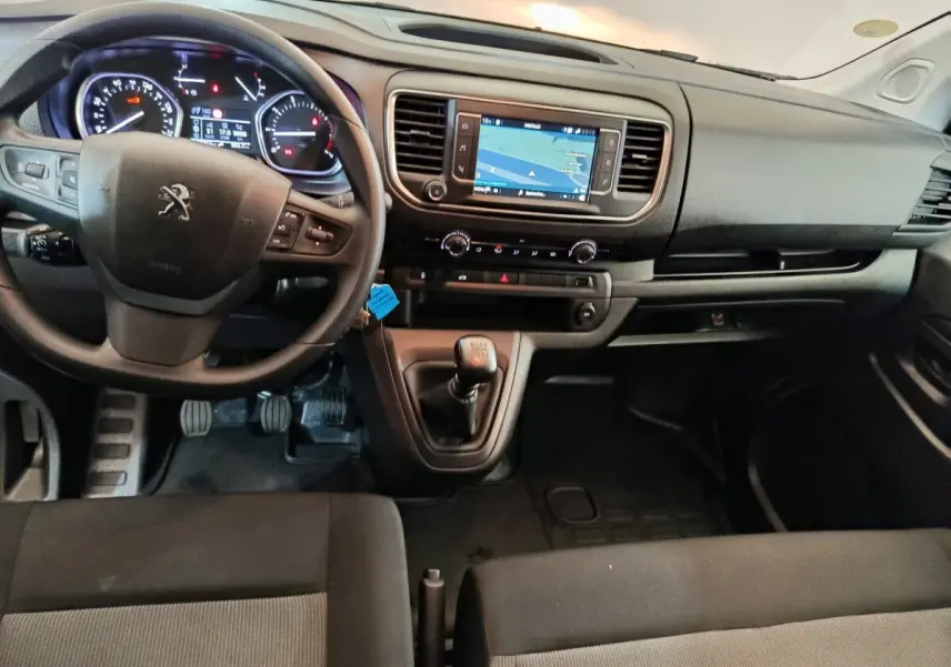 Vue intérieure avant du Peugeot Expert Fourgon 2023 avec tableau de bord noir et écran tactile central affichant la navigation.