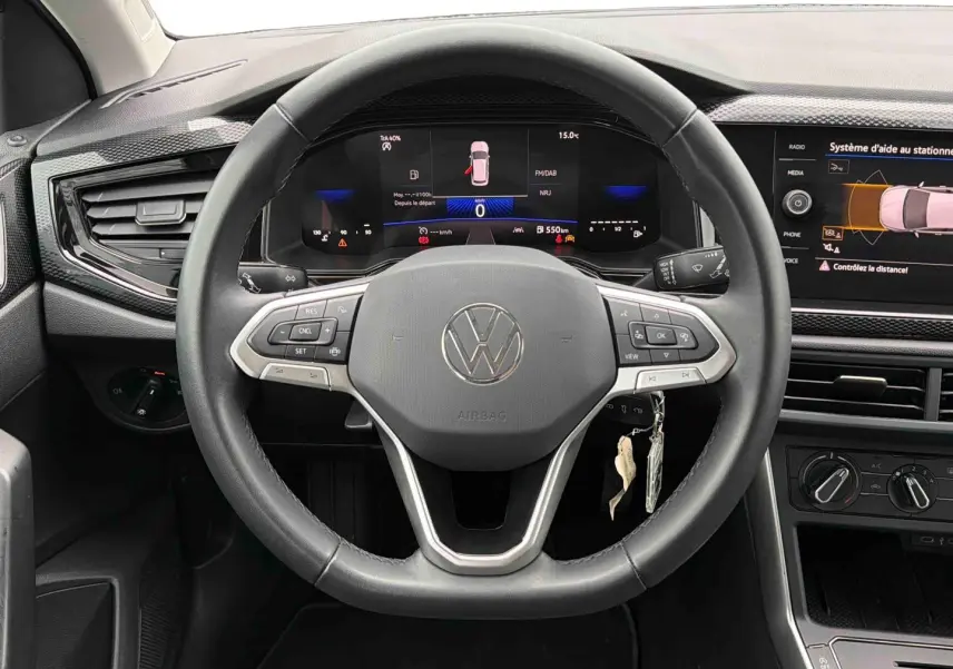 Vue intérieure centrée sur le volant multifonctions noir de la Volkswagen Polo 2025 avec tableau de bord digital et écran tactile.