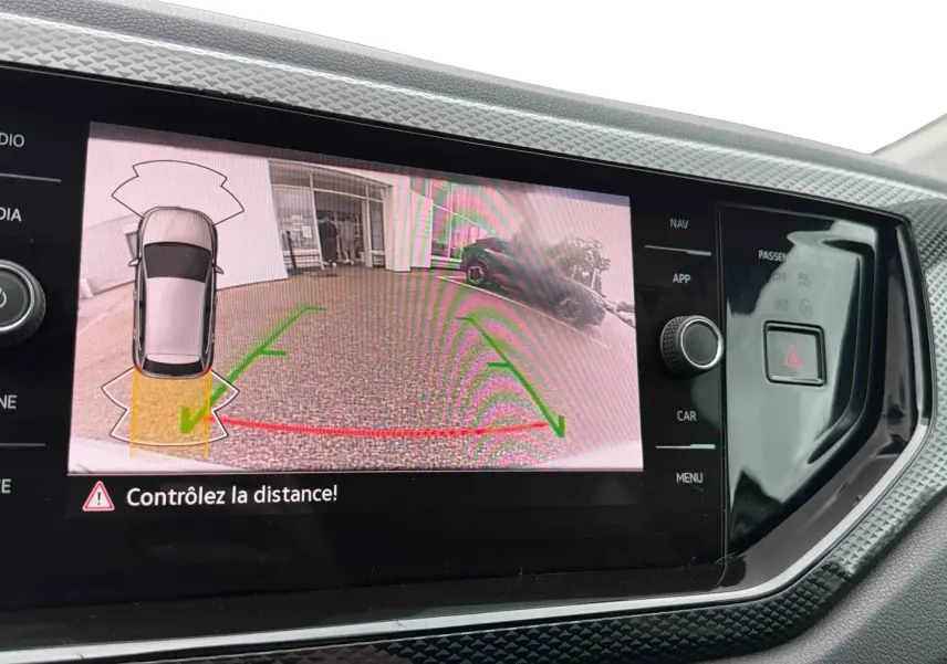 Écran tactile intérieur affichant la caméra de recul et l’aide au stationnement de la Volkswagen Polo grise.