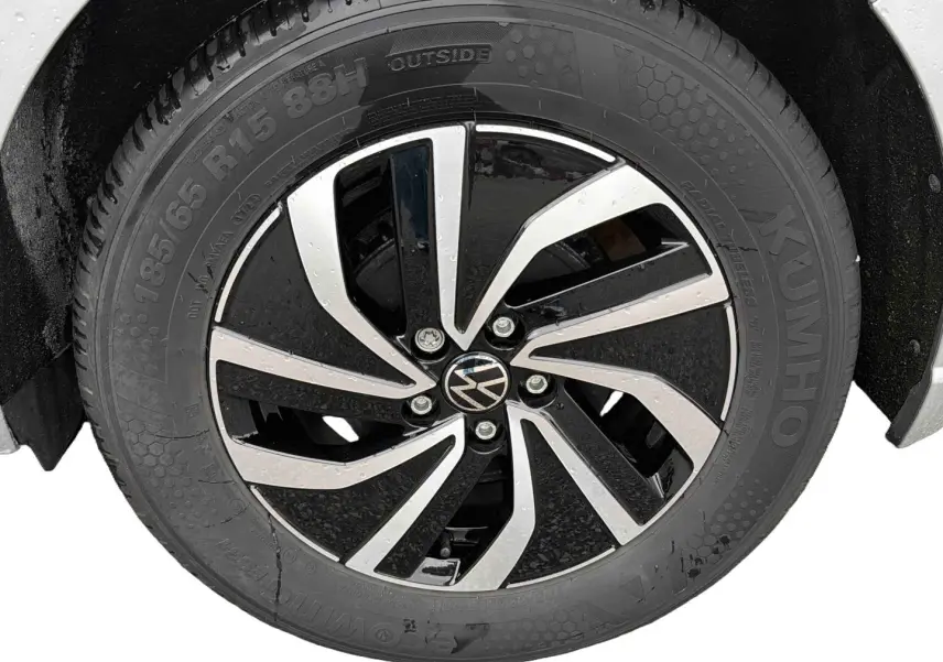 Gros plan sur la jante alliage 15 pouces bicolore noir et argent de la Volkswagen Polo grise 2025, pneu 185/65 R15 visible.