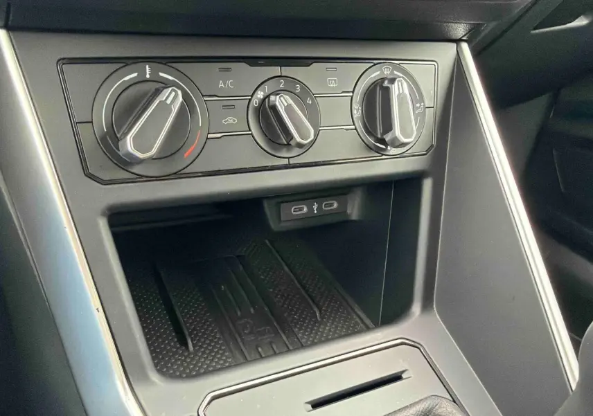 Vue rapprochée de la console centrale grise de la Volkswagen Polo 2025 avec commandes manuelles de climatisation et ports USB-C.