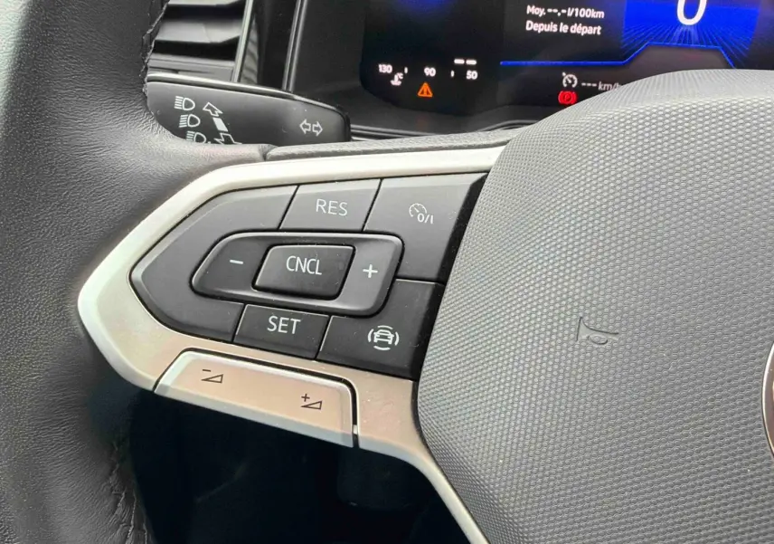Gros plan sur les commandes au volant à gauche de la Volkswagen Polo grise 2025 avec affichage digital du tableau de bord.