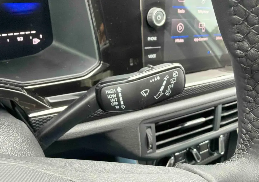 Vue rapprochée du commodo d’essuie-glace noir dans l’habitacle gris de la Volkswagen Polo 2025.