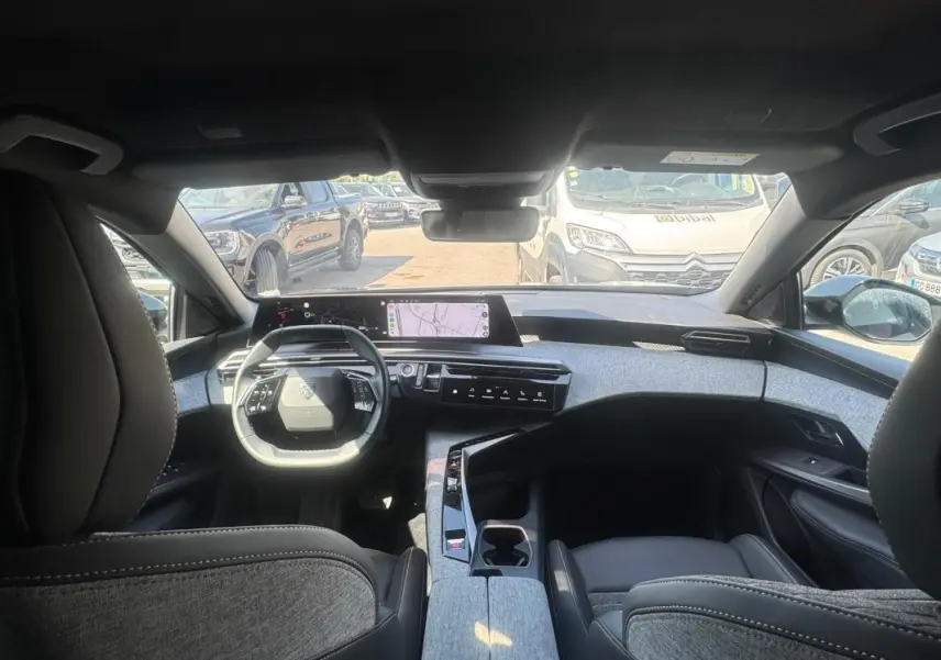 Vue intérieure avant du Peugeot 3008 Hybrid 136 e-DCS6 Allure 2025, mettant en valeur le cockpit numérique et les finitions grises.