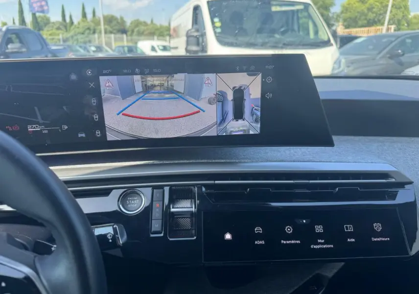 Vue intérieure du tableau de bord du Peugeot 3008 Hybrid 2025, avec écran numérique affichant la caméra de recul.