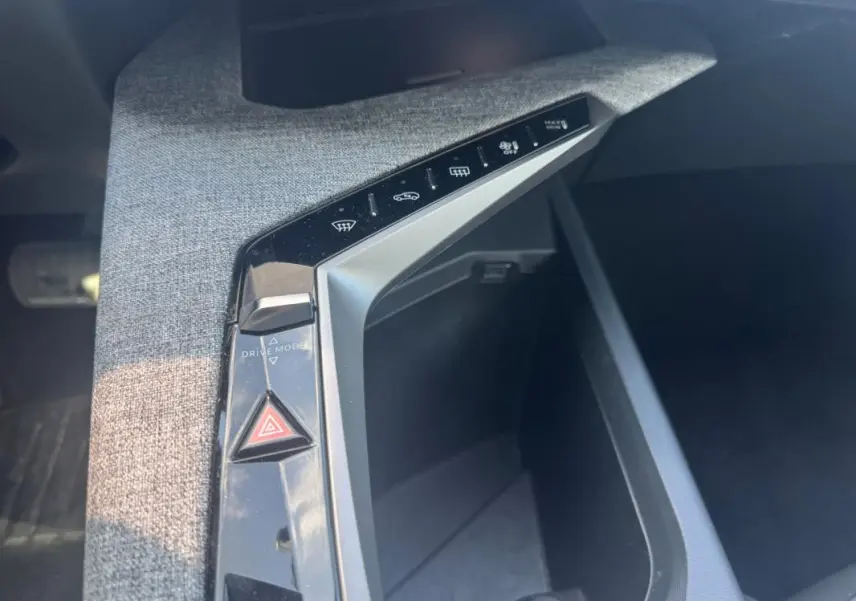 Vue rapprochée de la console centrale du Peugeot 3008 Hybrid 136 e-DCS6 Allure 2025, avec commandes tactiles et bouton triangle rouge.