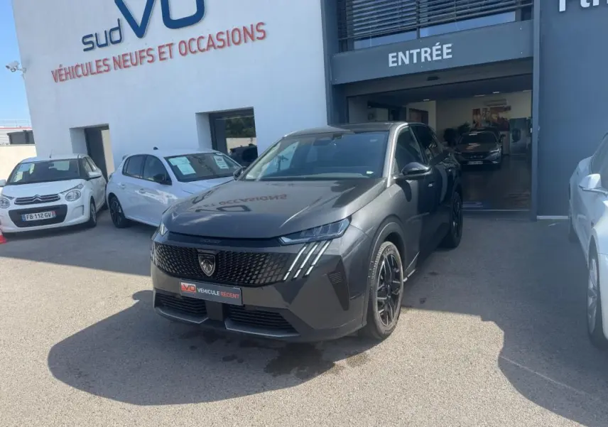 Peugeot 3008 Hybrid gris foncé en 3/4 avant droit, jantes alliage 19 pouces, devant entrée d’un showroom.