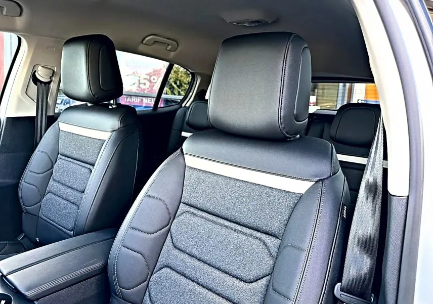 Vue intérieure côté droit montrant les sièges avant en cuir noir et tissu gris du Citroën C5 Aircross blanc.