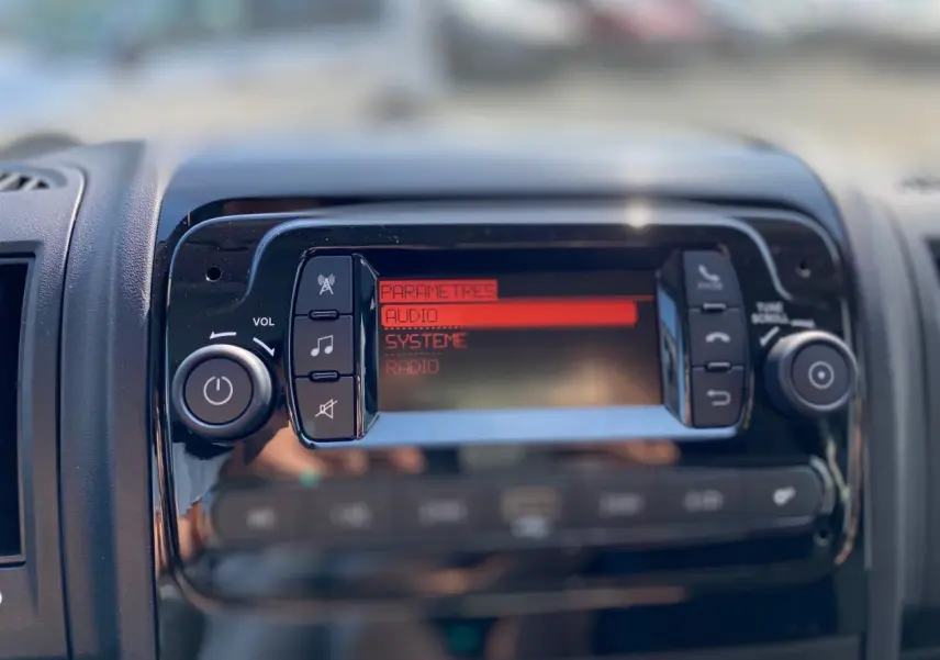 Tableau de bord du Citroën Jumper 2023 montrant l'écran audio en mode paramètres avec boutons de contrôle noirs.