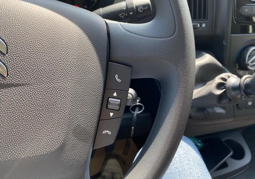 Gros plan sur le volant noir du Citroën Jumper 2023 avec commandes Bluetooth visibles côté gauche.