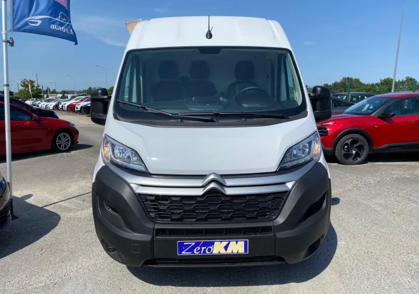 Vue frontale d’un utilitaire Citroën Jumper blanc avec calandre noire et plaque Zero KM visible au centre.