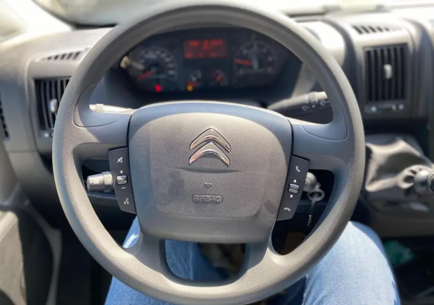 Volant Citroën Jumper 2023 vu de face avec commandes intégrées et tableau de bord en arrière-plan.