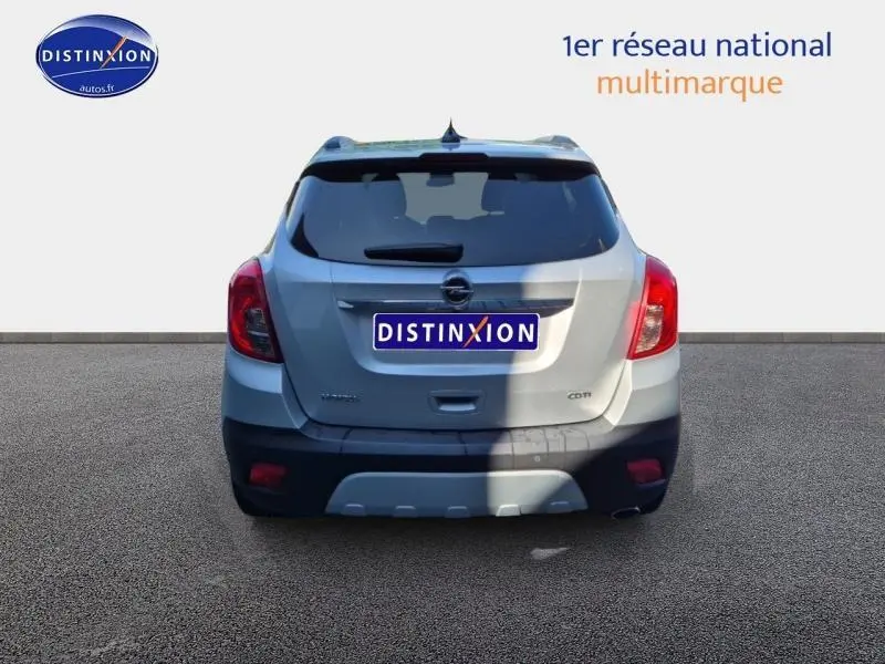 Vue arrière d'un Opel Mokka gris Astéroïde 2016 avec feux rouges et logo Opel visible sur fond neutre.