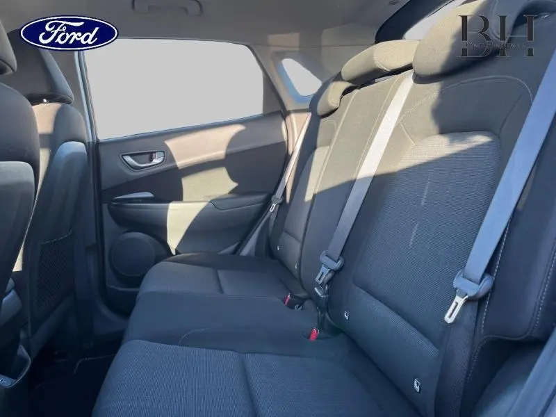 Vue intérieure côté gauche de la banquette arrière noire du Hyundai Kona 2022, avec ceintures de sécurité visibles.