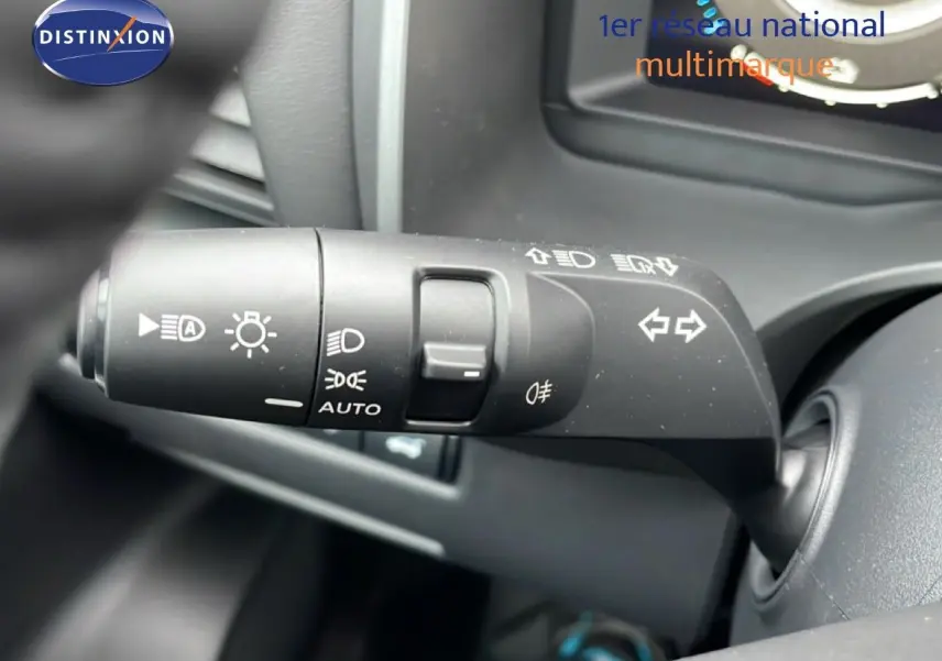 Gros plan sur la commande des feux et clignotants du Nissan Qashqai noir perle métal, intérieur côté gauche.