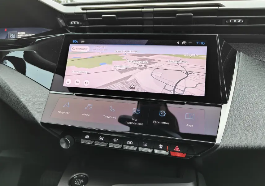 Vue rapprochée de l’écran tactile central noir du tableau de bord de la Peugeot 308 PureTech 130 Allure Pack 2023.