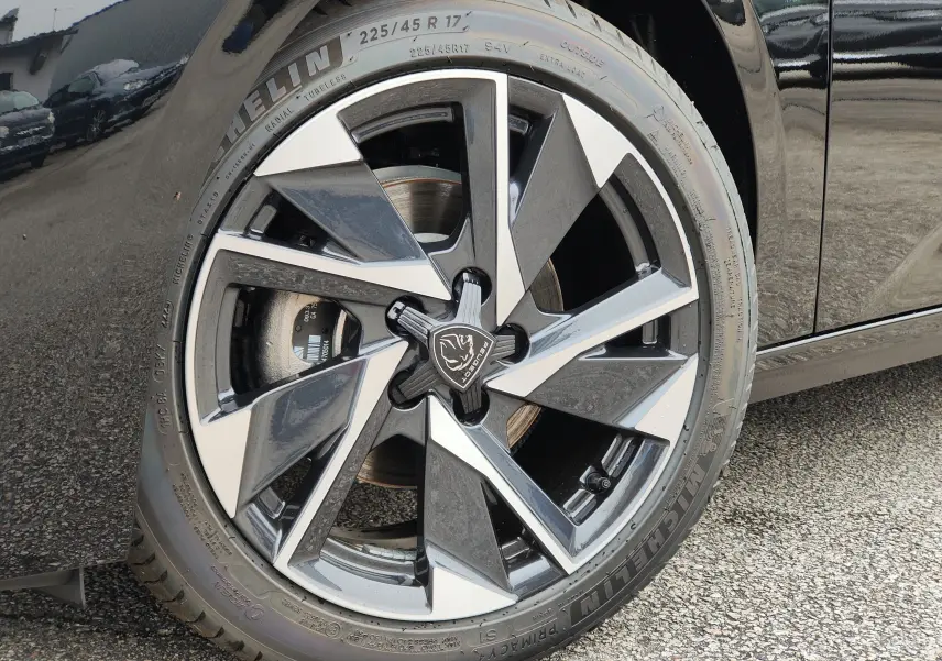 Gros plan sur la jante alliage 17 pouces bicolore noire et argentée de la Peugeot 308 PureTech 130 Allure Pack noire 2023.