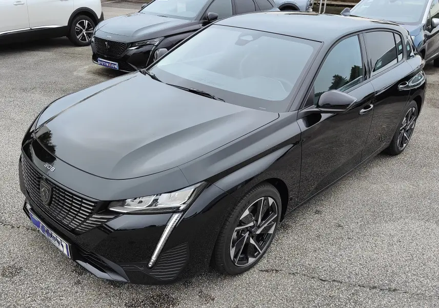 Peugeot 308 PureTech 130 Allure Pack noire vue en 3/4 avant droit, avec jantes bi-ton et feux LED distinctifs.