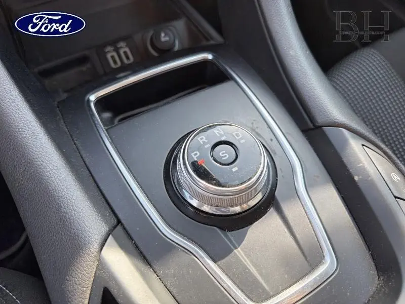 Vue rapprochée de la molette de sélection de la boîte automatique sur la console centrale noire du Ford Mondeo gris millenium.