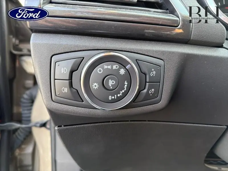 Gros plan sur le bouton de commande des phares et feux antibrouillard dans l'habitacle d'une Ford Mondeo gris millenium.