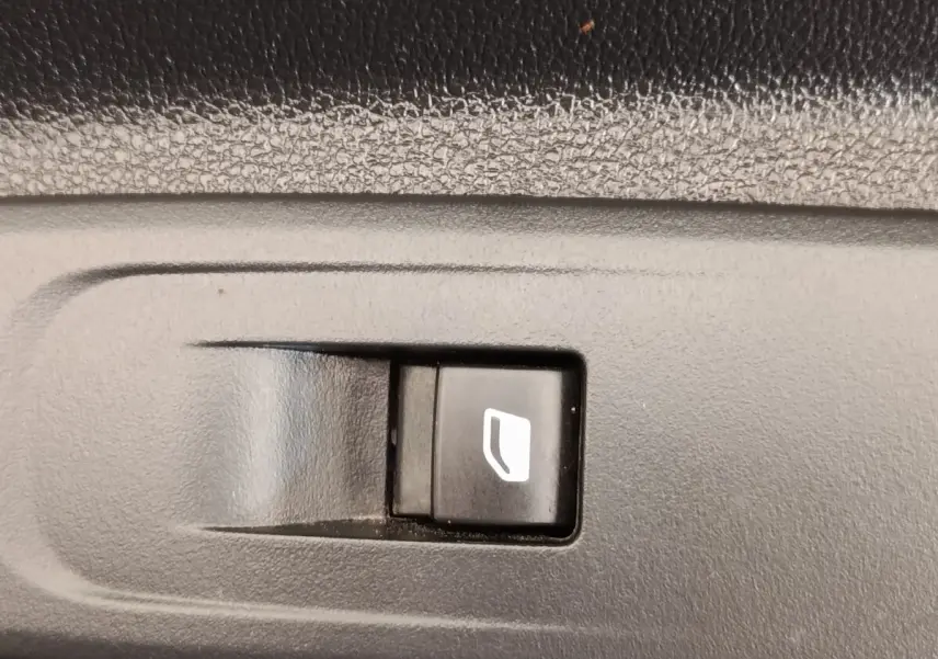 Gros plan sur le bouton de commande de vitre électrique dans l'habitacle d'un Peugeot Partner blanc 2022.