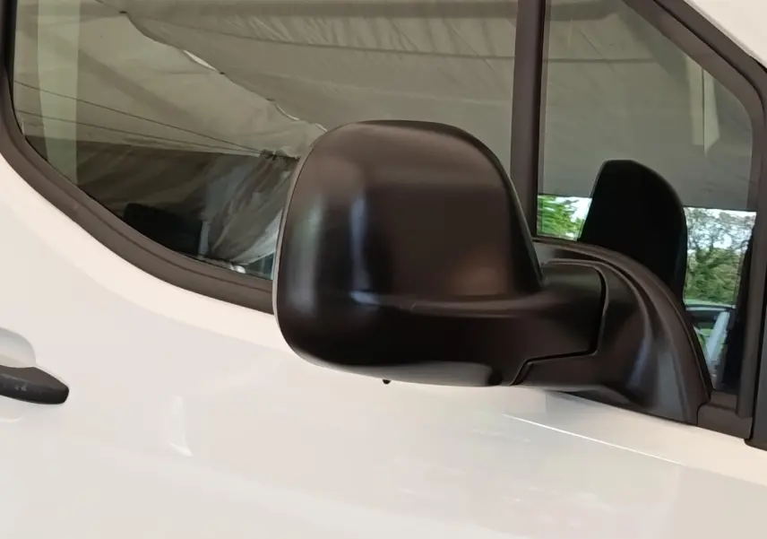 Gros plan sur le rétroviseur noir côté conducteur du Peugeot Partner blanc 2022, vue latérale rapprochée.
