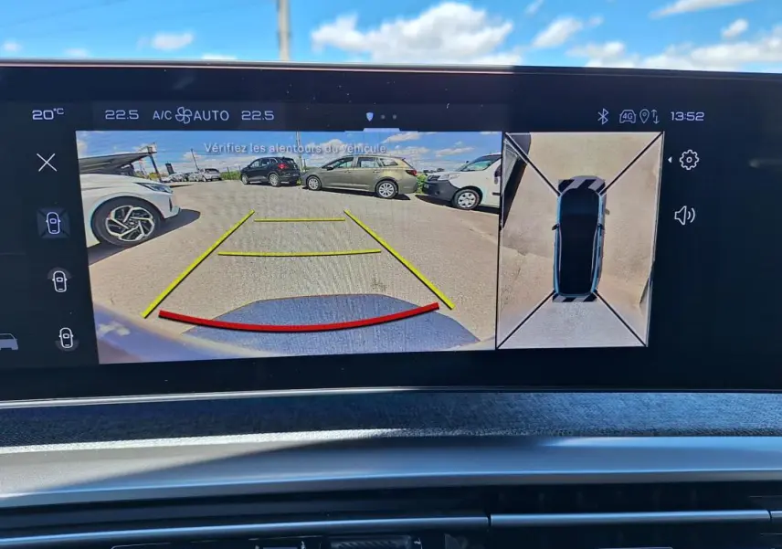 Écran multimédia du Peugeot 3008 Hybrid gris foncé montrant la caméra de recul et la vue 360° du véhicule en stationnement.