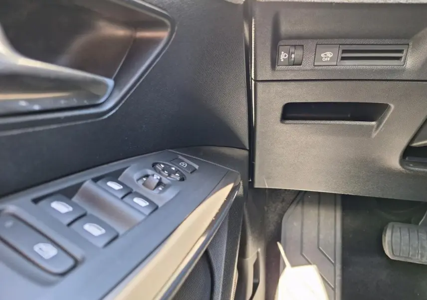 Détail des commandes des vitres et rétroviseurs côté conducteur du Peugeot 3008 Hybrid gris foncé, intérieur noir.