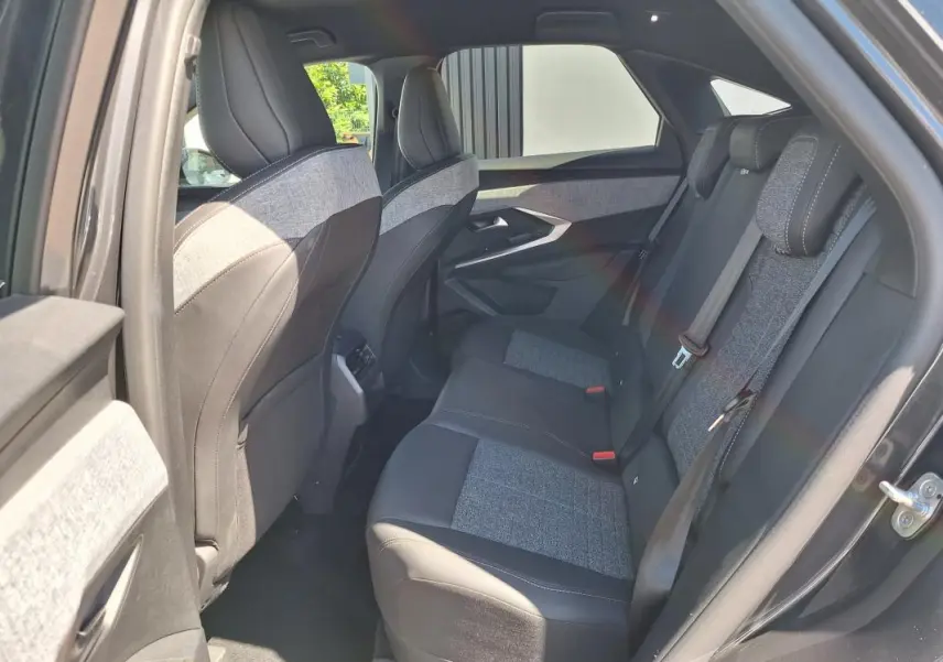 Vue intérieure côté droit des sièges arrière du Peugeot 3008 Hybrid gris foncé, avec sellerie tissu et cuir bicolore.