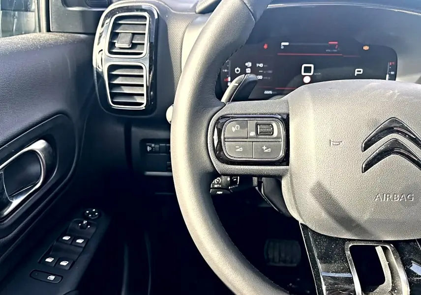 Vue rapprochée du volant noir multifonction et du tableau de bord numérique du Citroën C5 Aircross 2025.