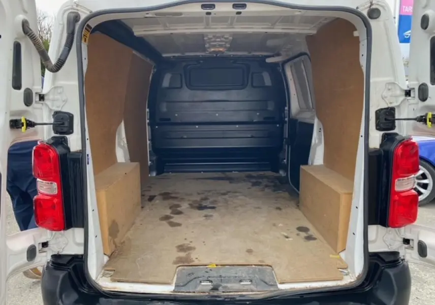 Vue arrière ouverte du Citroën Jumpy blanc 2019 avec plancher et habillage bois dans l'espace de chargement.